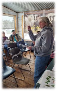 Woman stands in front of group of people explaining gardening